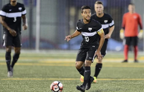 Jean Abreu conduzindo a bola em partida noturna pela University of Bridgeport